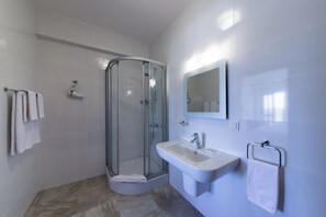 Chambre Double Deluxe, 1 grand lit, balcon, vue partielle sur la mer | Salle de bain | Douche, articles de toilette gratuits, sèche-cheveux, chaussons
