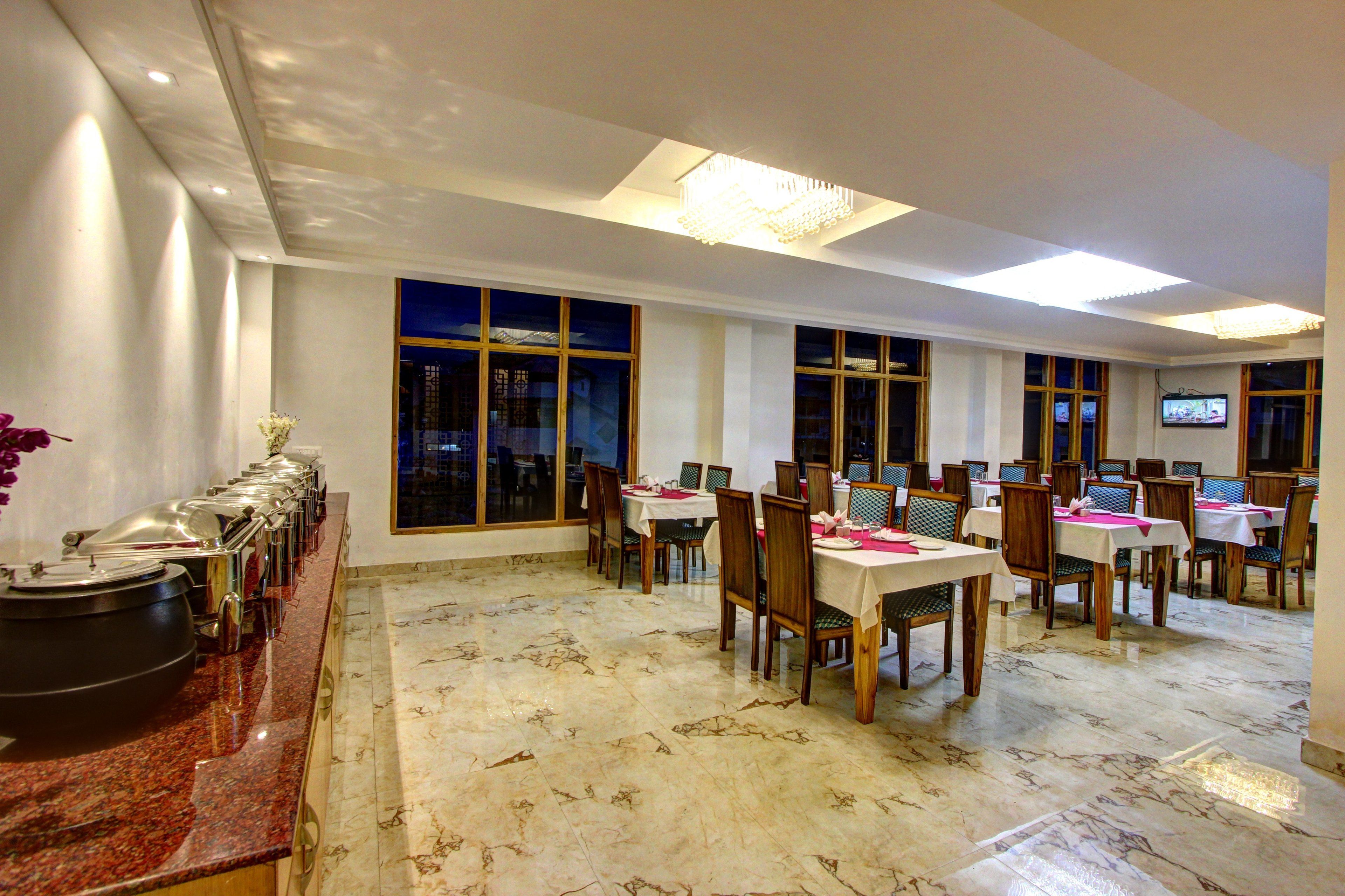 A dining area with marble flooring, wooden chairs, and tables set for a meal.