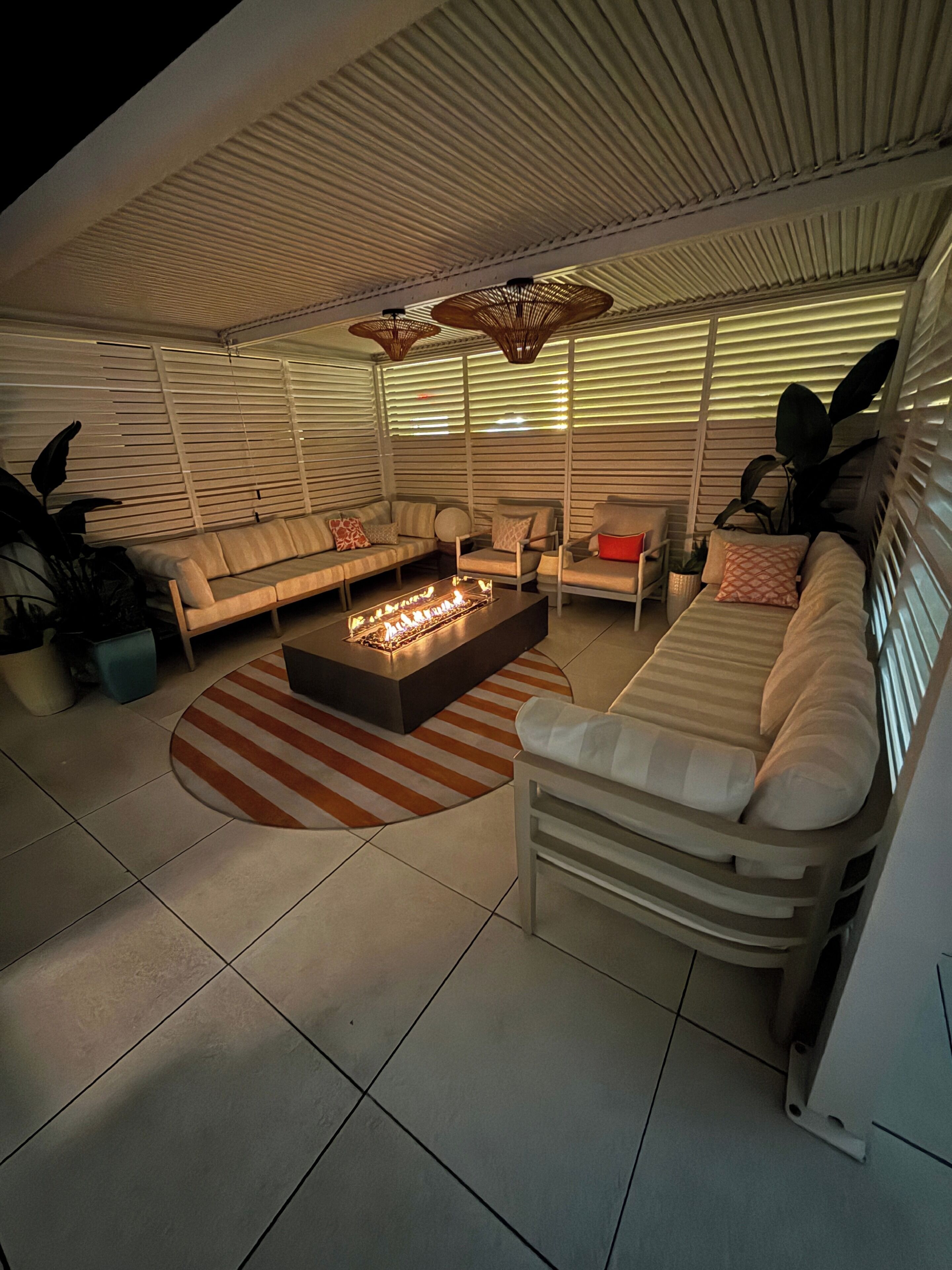 A modern living room with a fireplace, sofas, and a striped rug.