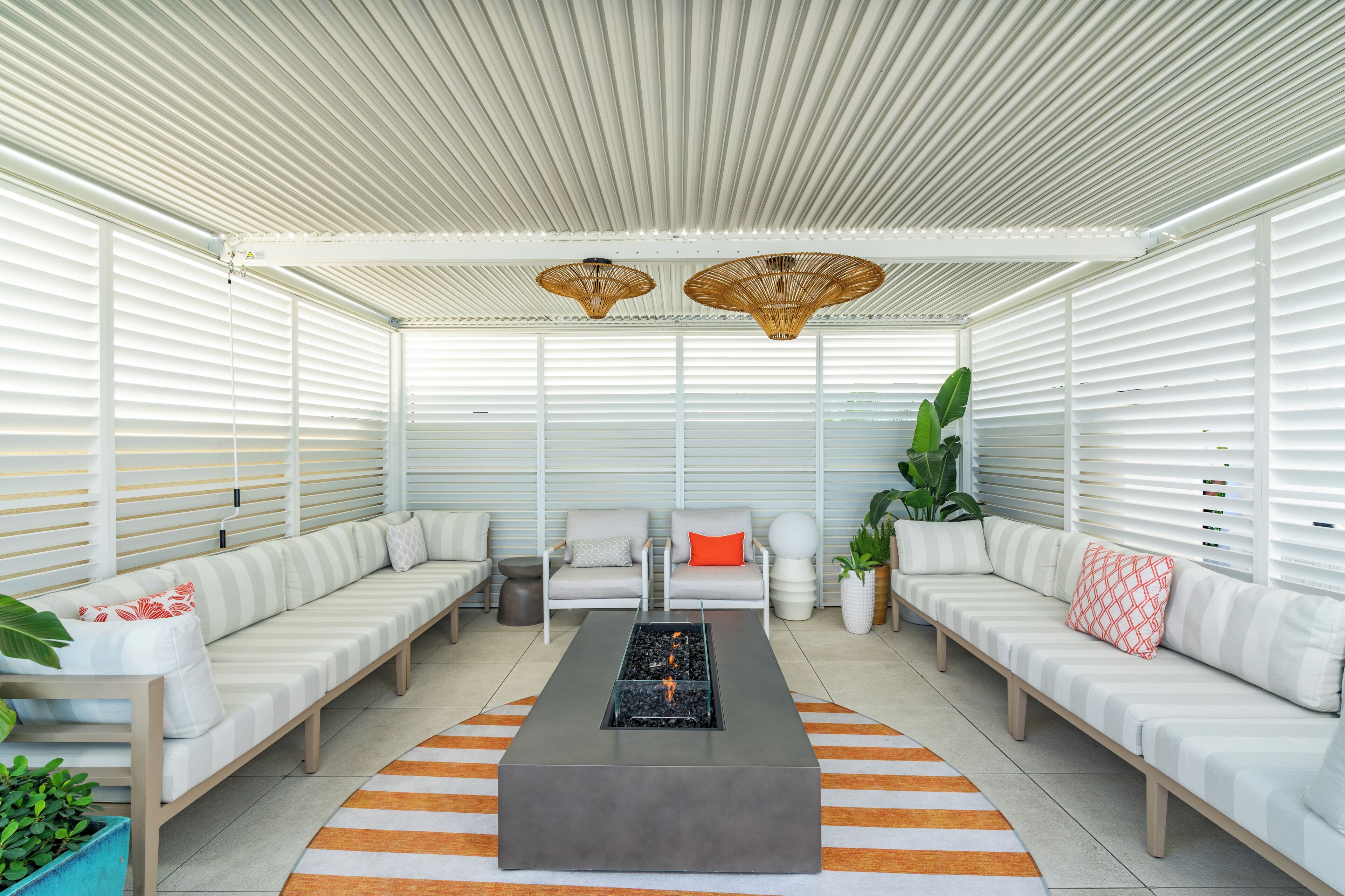 A modern lounge area with a sofa set, a coffee table, and two hanging wicker lamps.