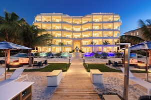 Un hotel de varios pisos con un patio central, mobiliario exterior y zona de piscina.