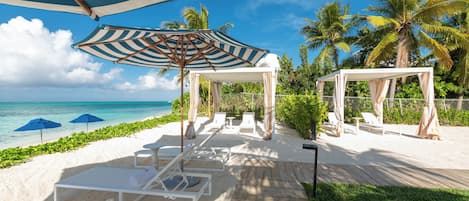 Un complexe hôtelier en bord de mer, doté de chaises longues, de parasols et d’une terrasse en bois.