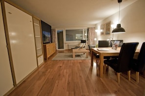 Relax in this inviting living room with a dining area, TV, and comfortable seating.