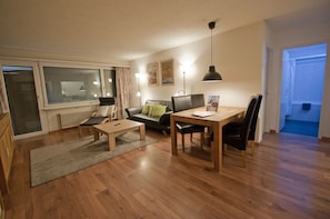 Relax in a cozy seating area with a sofa, armchairs, and dining table.