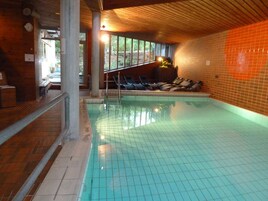 Una piscina techada, sillones reclinables de piscina