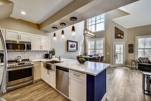 Enjoy cooking in this well-lit kitchen with a central island, dishwasher, stove, and microwave.