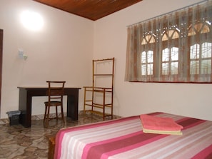 Ein Schlafzimmer mit einem Bett, einem Schreibtisch und einem Stuhl.