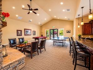 A spacious indoor area with a pool table, multiple seating arrangements, a ceiling fan, and a stone accent wall. - Park's Edge 844 (Kamas)