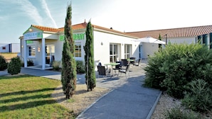 A hotel with outdoor seating and a sign for 'La Auberge de Mobico'. - Logis L'auberge de Moricq (Angles)