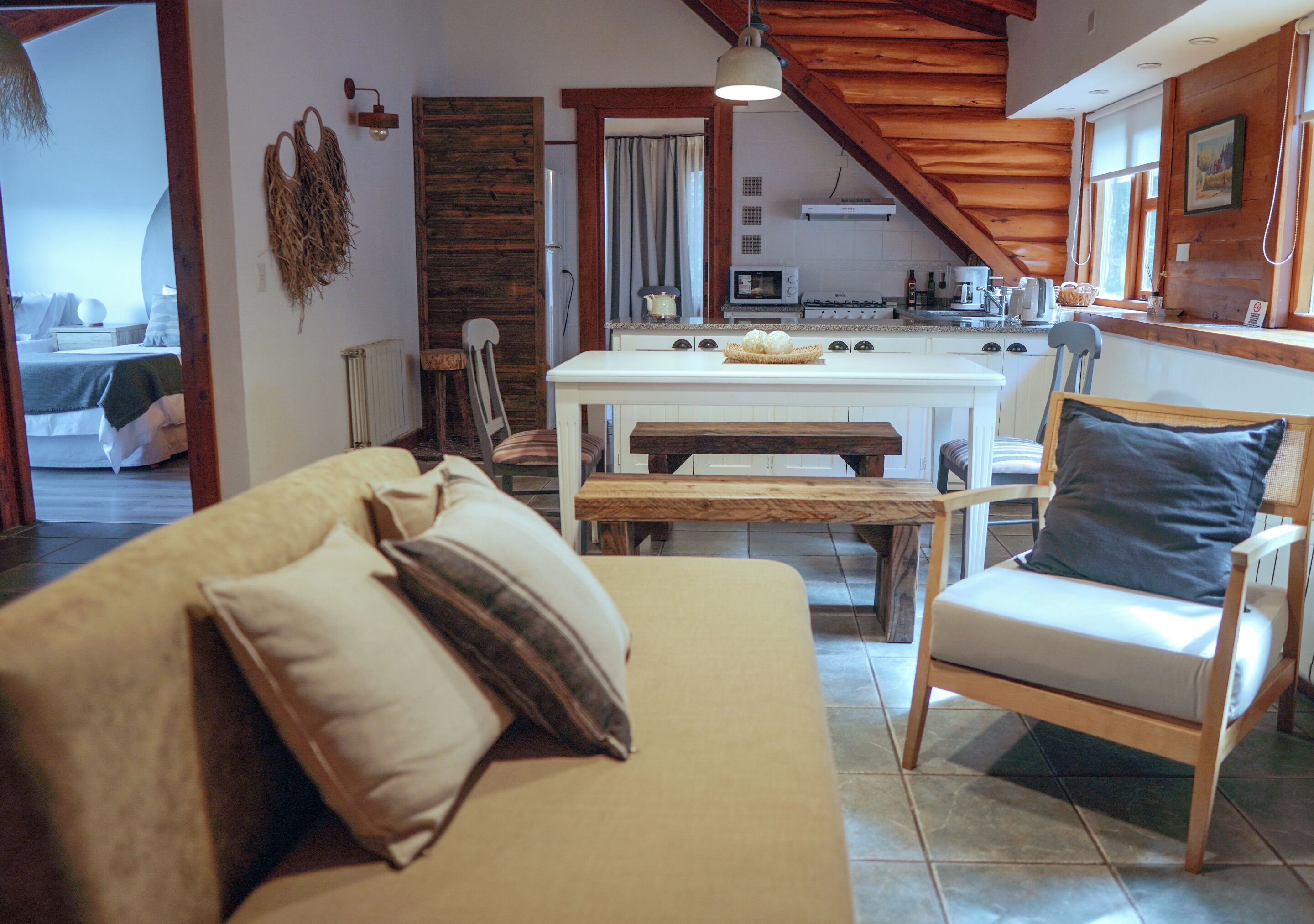 A cozy living room with a sofa, a chair, and a wooden dining table.