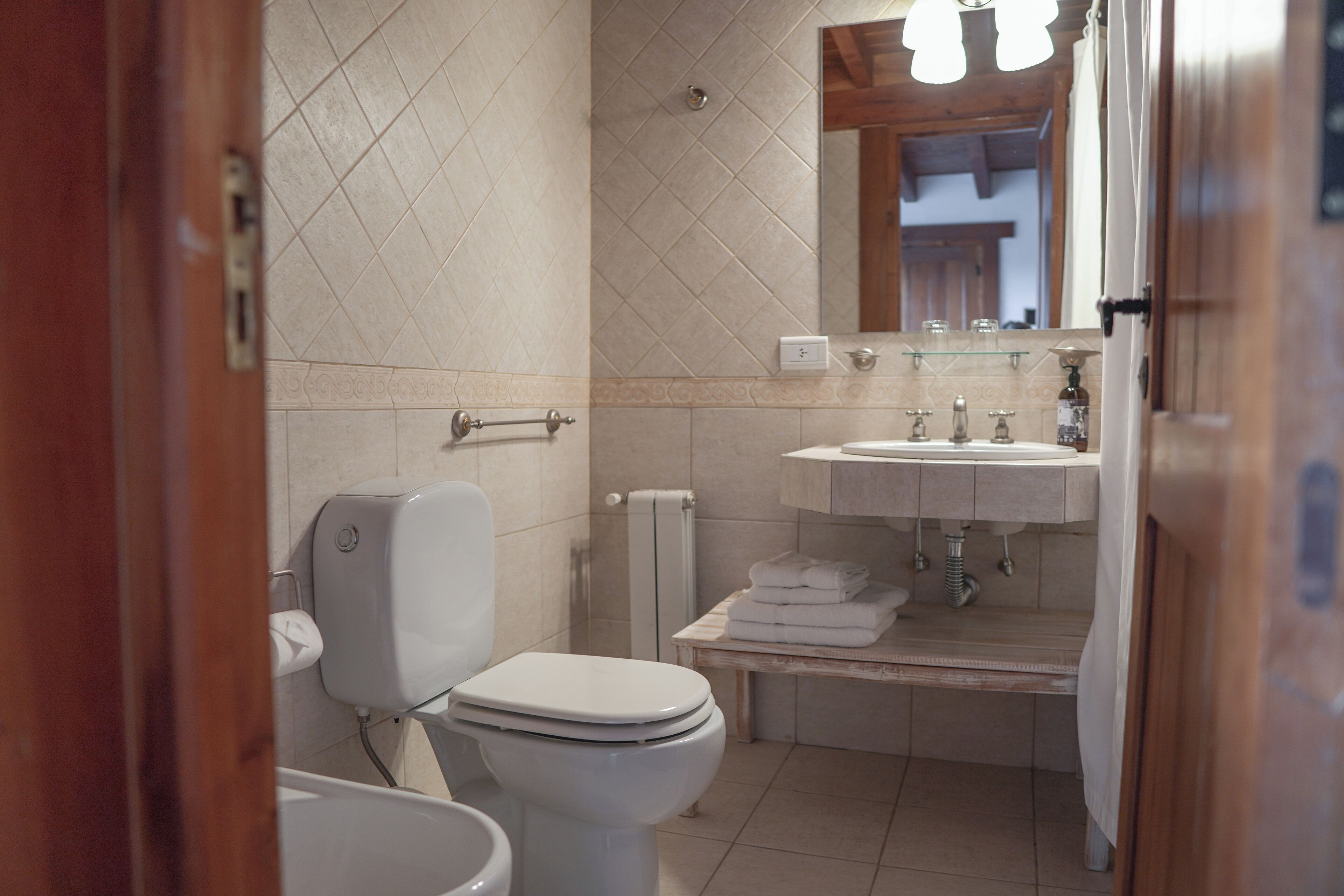 Une salle de bain avec des toilettes, un lavabo et un miroir.