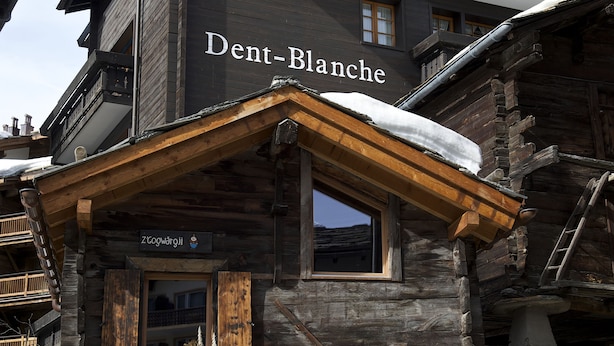 Un edificio de madera con un letrero que dice "Dent-Blanche".