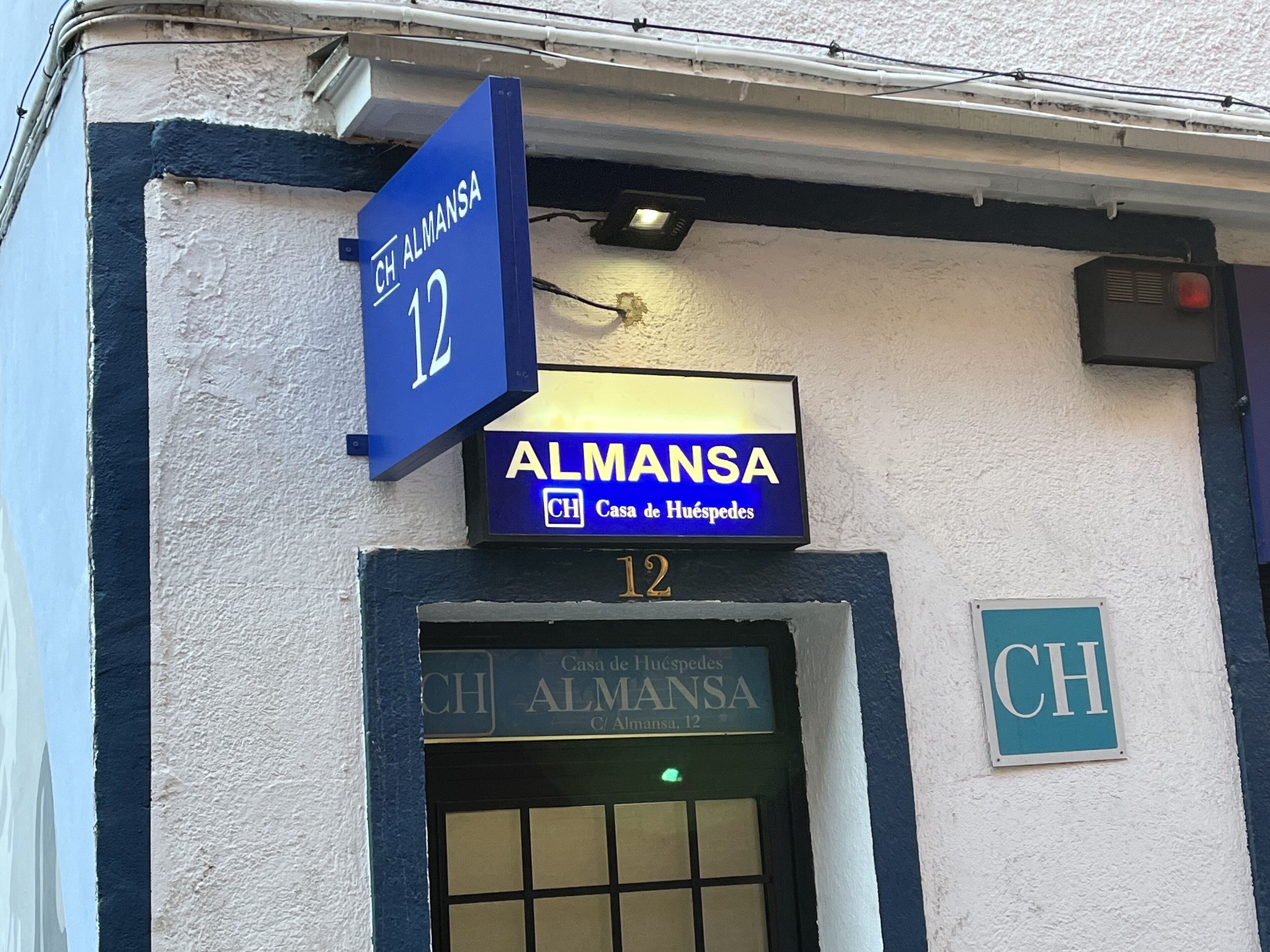 A building facade with a sign reading "CH ALMANSA 12 Casa de Huéspedes".