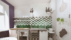 A compact kitchen with a herringbone-patterned backsplash, white cabinetry, and a small dishwasher. - Go2Krynica - Gawra (Krynica-Zdroj)