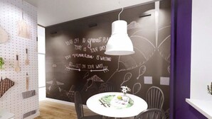 A modern dining area with a round table, chairs, and a chalkboard wall with motivational writing. - Go2Krynica - Gawra (Krynica-Zdroj)