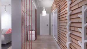 A modern hallway with a wooden slat wall, a white door, and a hanging light fixture. - Go2Krynica - Gawra (Krynica-Zdroj)