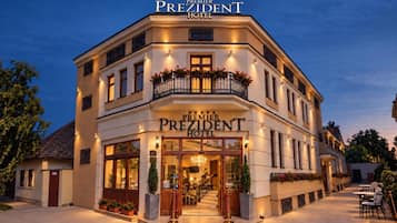 Das Premier President Hotel mit einer imposanten Eingangshalle, großen Fenstern und einer gut beleuchteten Fassade.