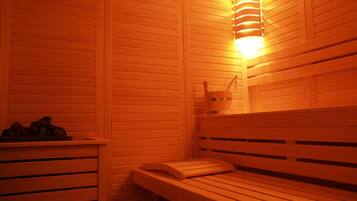 A sauna with wooden benches and a wall-mounted light fixture.