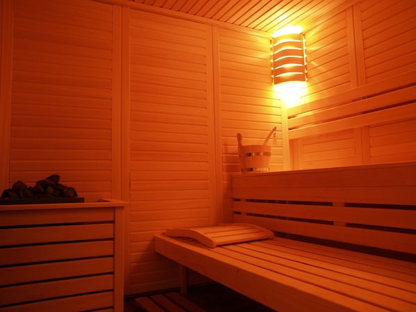 Eine Sauna mit Holzbänken und einer Wandleuchte.