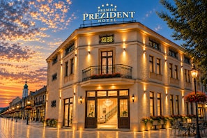 Un hôtel avec une enseigne bien visible, un balcon doté de balustrades et une entrée bien éclairée.