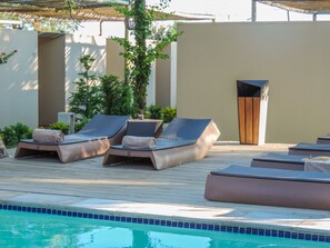 A poolside area with lounge chairs and a small pool.