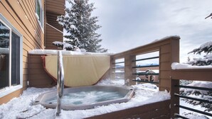 A hot tub on a wooden deck with snow around it. - 522 Watch Hill (Silverthorne)