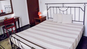 A bedroom with a bed, a desk, a chair, a lamp, and a door. - Villa Kalin (Veliko Tarnovo)