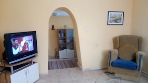 A living room with a TV, a sofa, a coffee table, and a bookshelf. - Villa Kalin (Veliko Tarnovo)