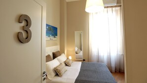 A hotel room with a bed, a large mirror, a window with curtains, and a number '3' on the wall. - I Viceré B&B Deluxe (Naples)