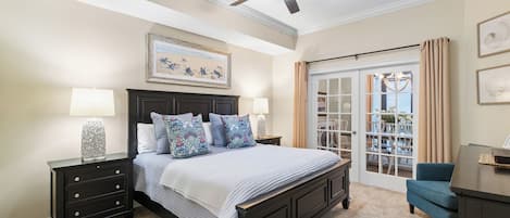 A bedroom with a bed, nightstands, a dresser, a ceiling fan, and a view through a glass door.