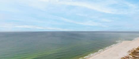A beach with clear water and a sandy shore.