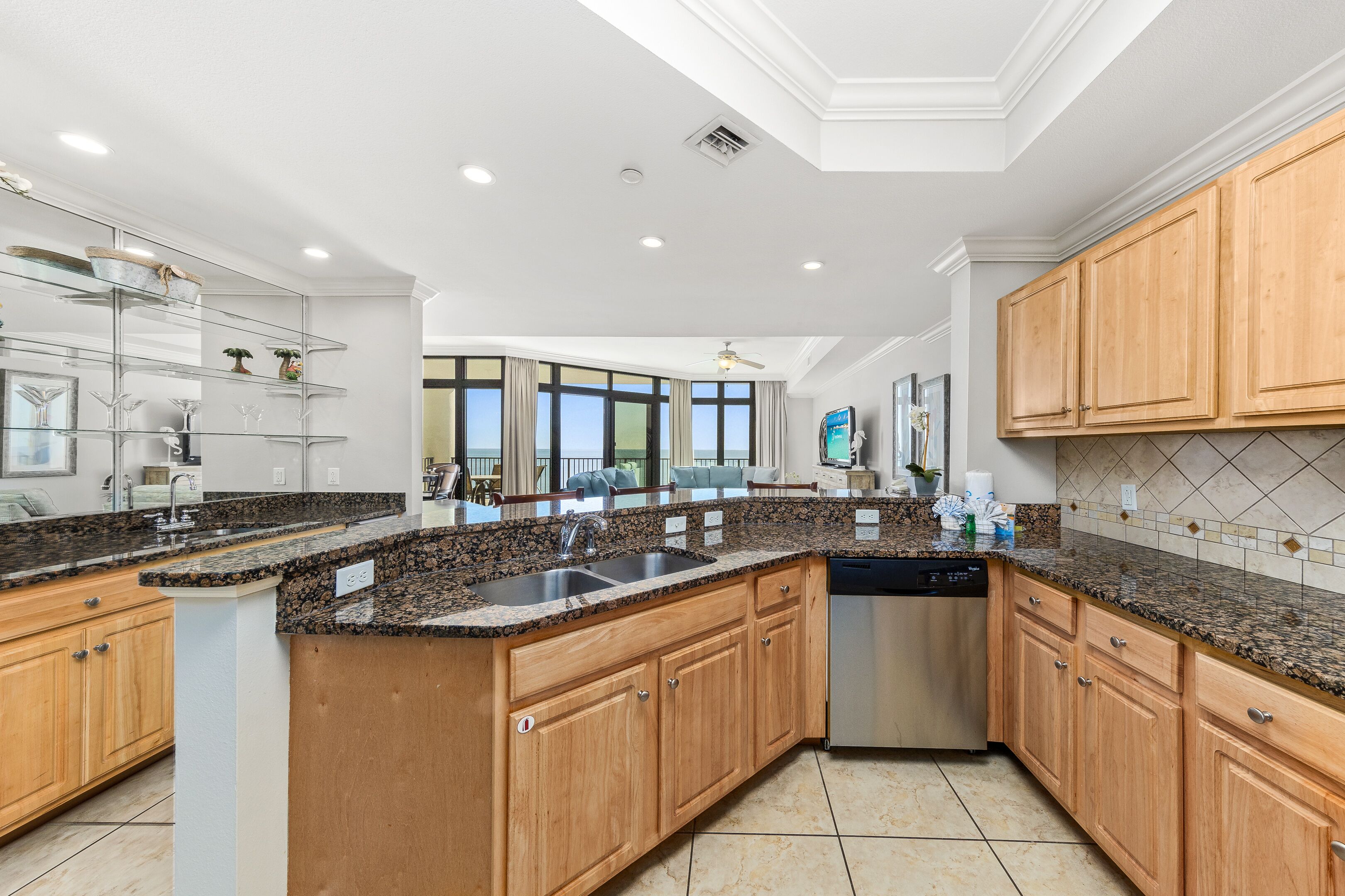 A modern kitchen with granite countertops, wooden cabinets, and a dishwasher.
