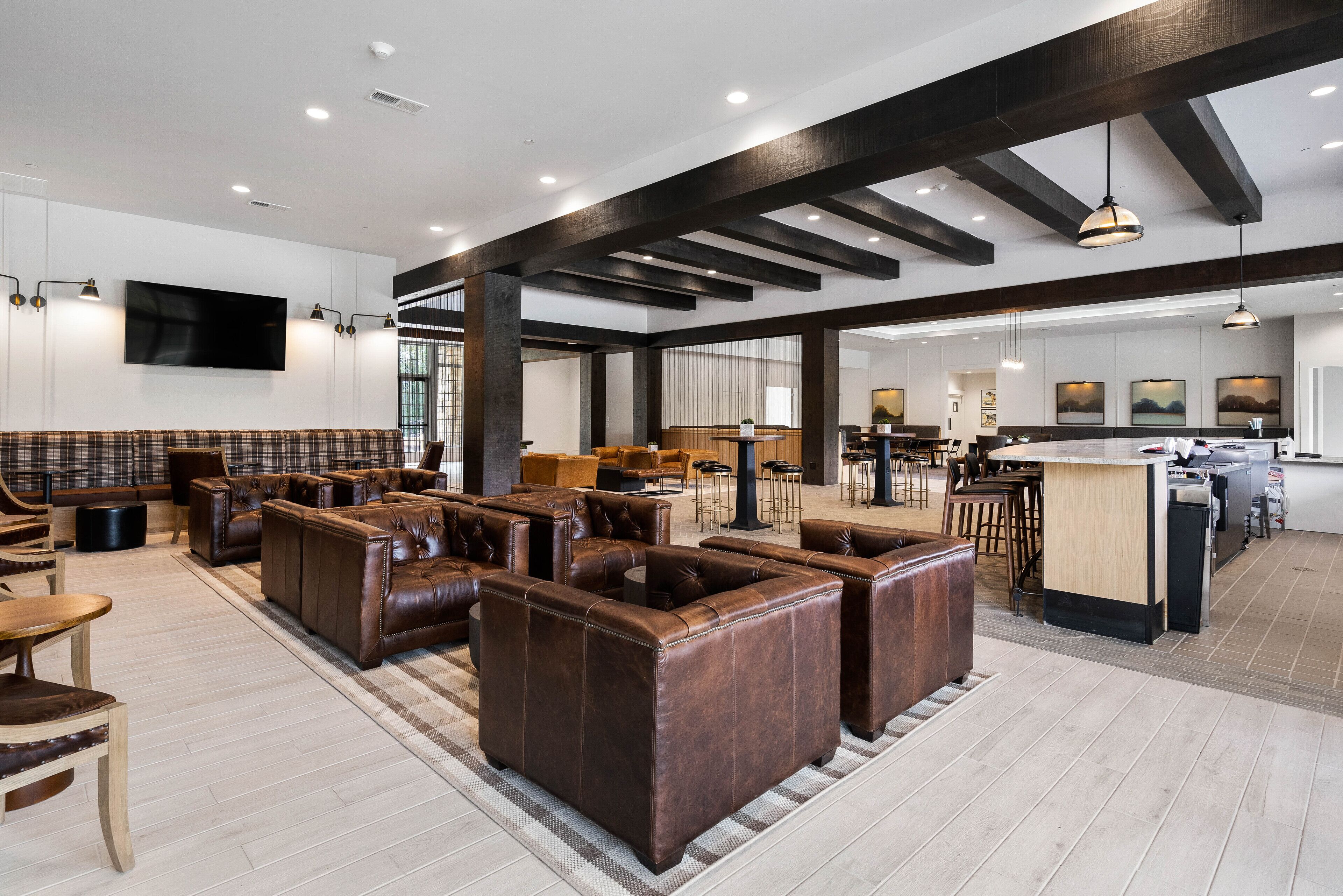 Un hall amplio con sofás de cuero, un mostrador de recepción y una zona de cocina.