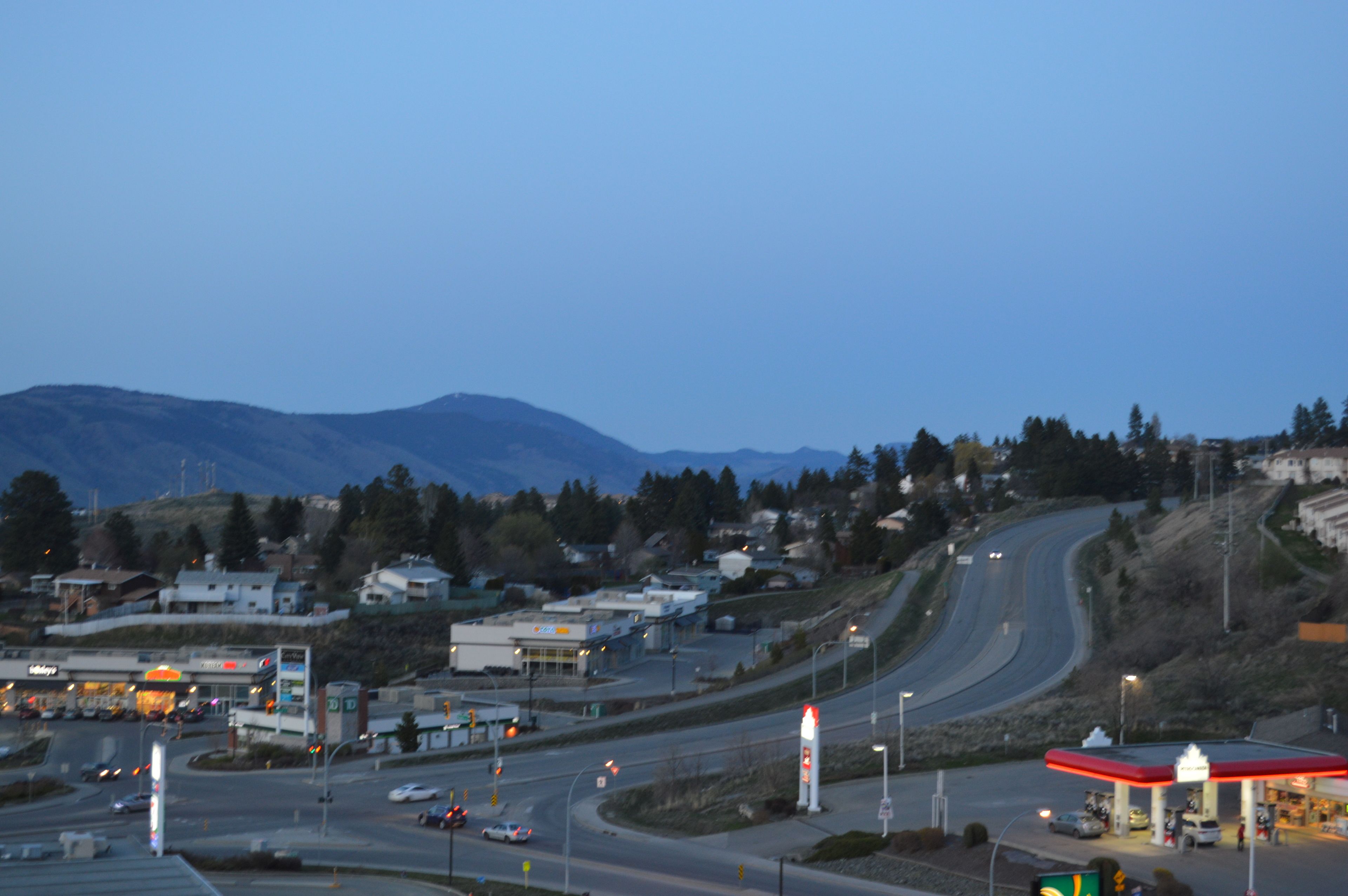 A highway interchange with multiple lanes and a gas station on the right.