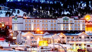 Un hôtel à plusieurs étages, une enseigne bien visible indiquant « Wingate by Wyndham », et une station-service au premier plan.
