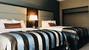 Une chambre d’hôtel avec deux lits, une table de chevet avec une lampe et une grande fenêtre.
