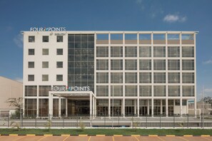 A modern building with the sign "FOUR POINTS BY SHERATON" indicating a hotel.