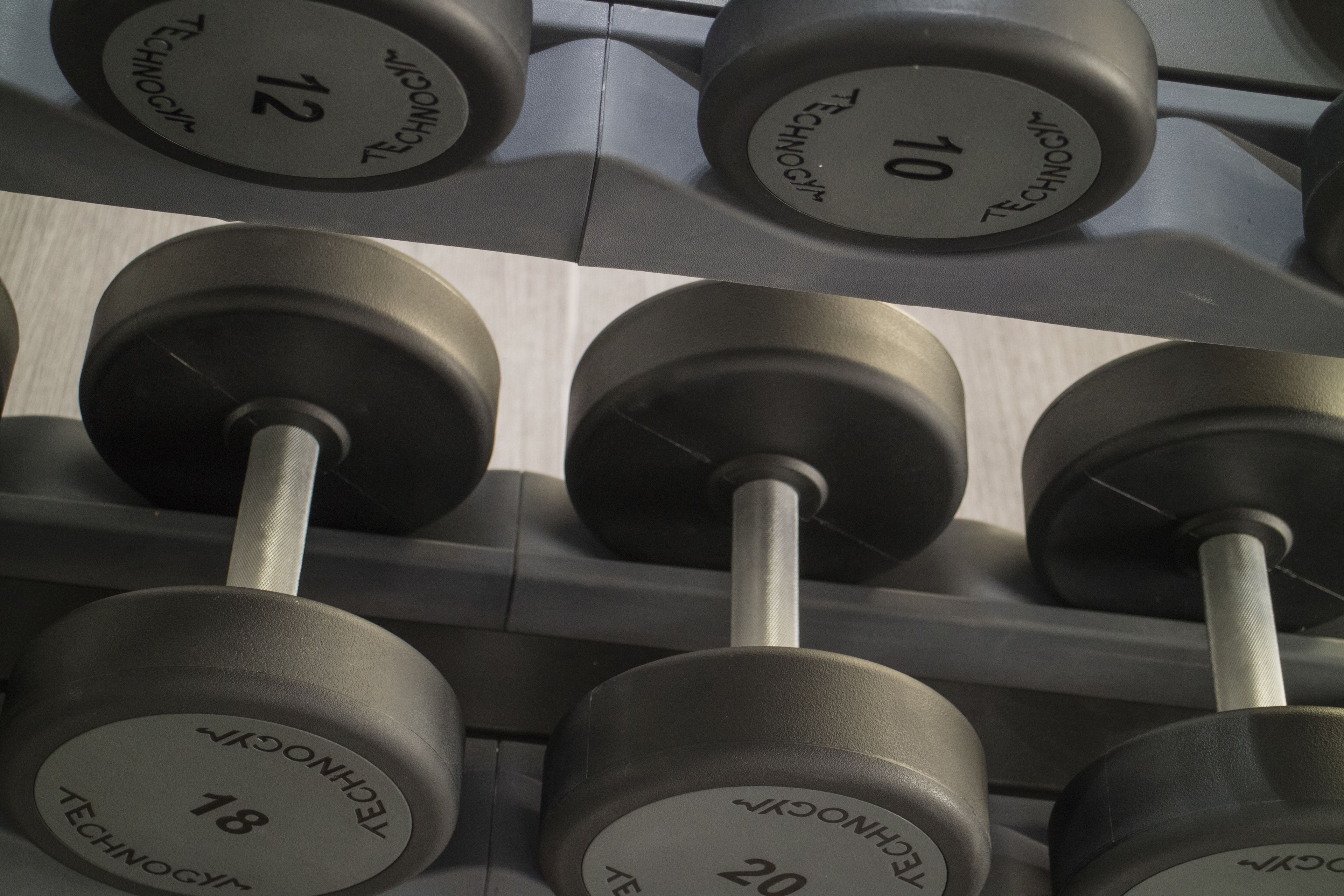 A rack of dumbbells with weights labeled from 10 to 20.