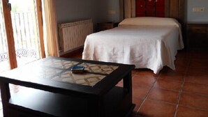 Un dormitorio con cama, una mesa y vistas al exterior.