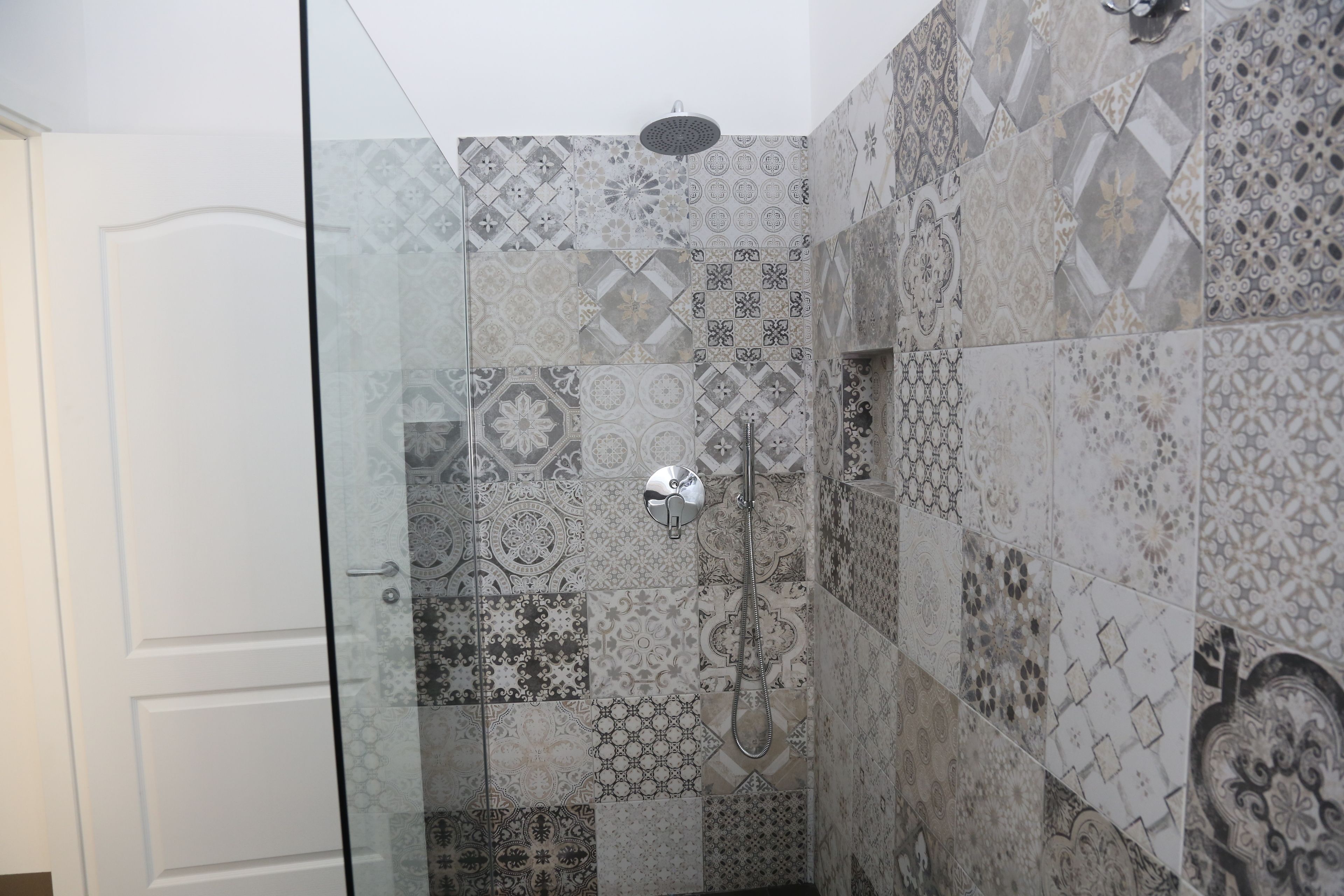 A shower with a glass door and a showerhead.
