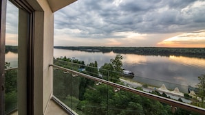 Un balcon donnant sur une rivière et la végétation environnante.