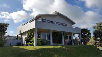 A modern two-story house with a flat roof and a covered porch.