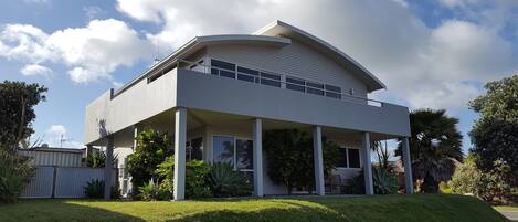 A modern two-story house with a flat roof and a covered porch.