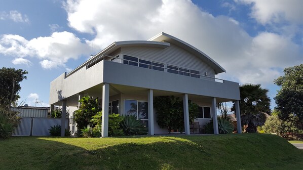 A modern two-story house with a flat roof and a covered porch. - Apartment by The Beach (Tauranga)