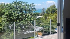 Uma varanda com vista para árvores e um corpo d'água.