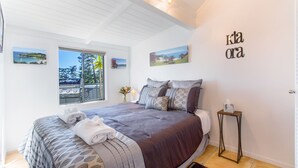 Ein Schlafzimmer mit einem Bett, einem Fenster mit Blick und einer Wand mit einem Schild.