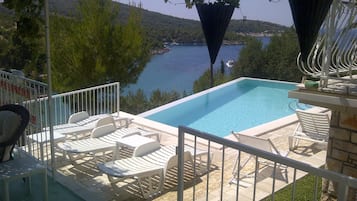 Una piscina al aire libre, una piscina infinita, camas de piscina gratis