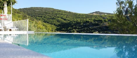 Outdoor pool, an infinity pool, open 8:00 AM to 9:00 PM, free cabanas