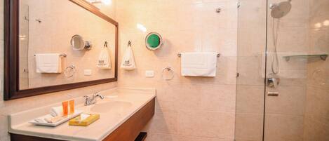 A bathroom with a sink, mirror, towel rack, and shower.