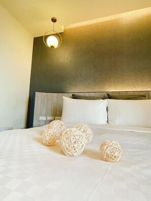 A hotel room with a bed, bedside lamps, and a headboard. - Hotel Golden Bay Kenting (Hengchun)